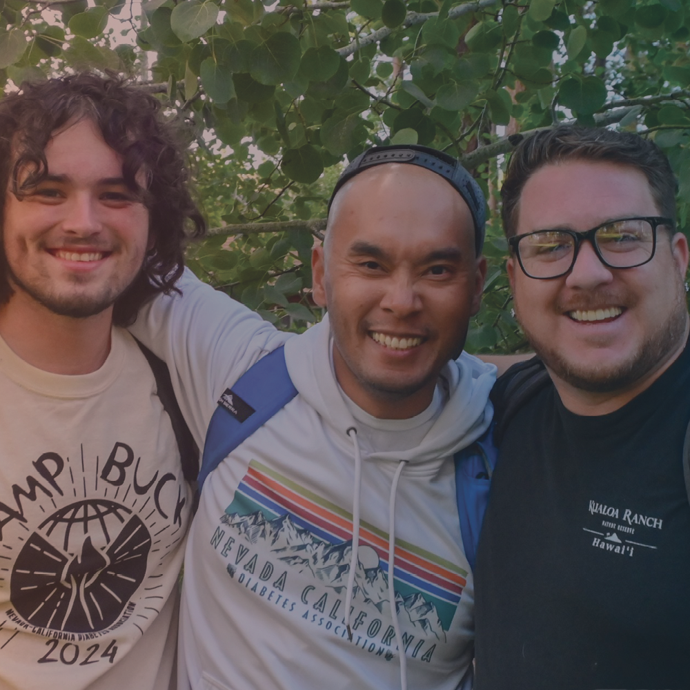 Three men smiling together.