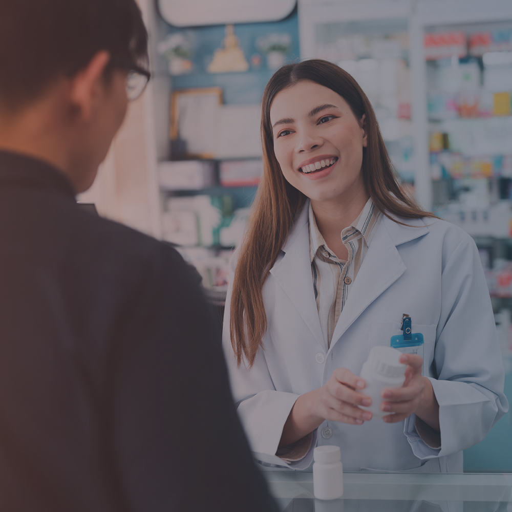 A woman at a pharmacy helping a customer.