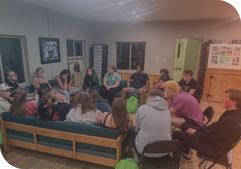 A group of people inside a cabin sitting in a circle together.