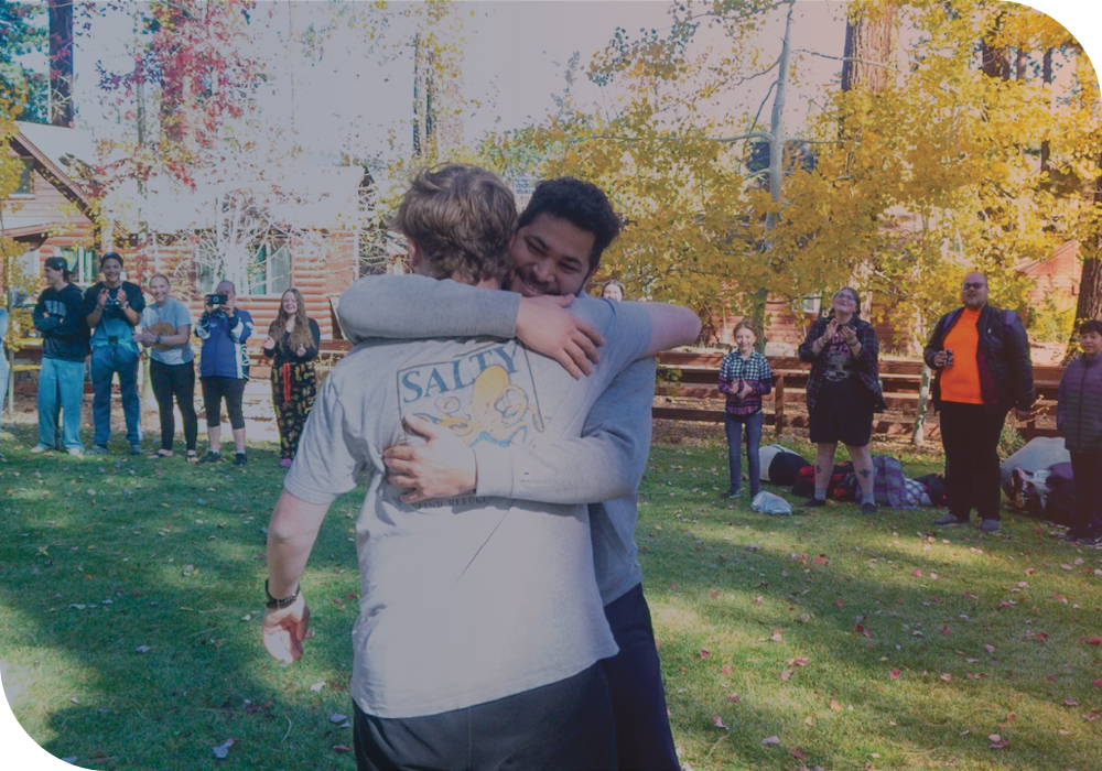 Two young men hugging each other.